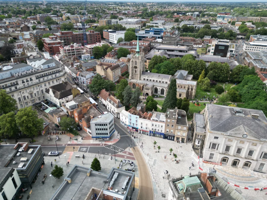 Aerial view of a historic town center with a church and surrounding buildings.